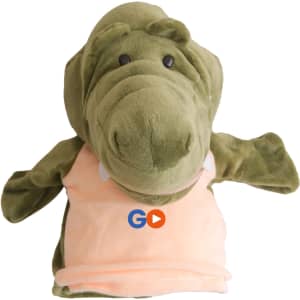 A green crocodile hand puppet with a soft texture and a light peach-coloured shirt, featuring a logo on it.