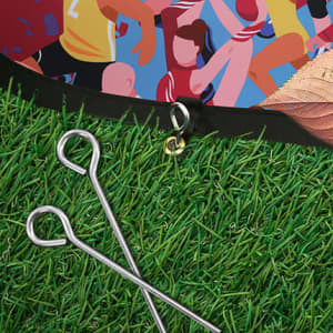 A small horizontal pop-up banner featuring a vibrant design, set against green grass with two silver stakes.