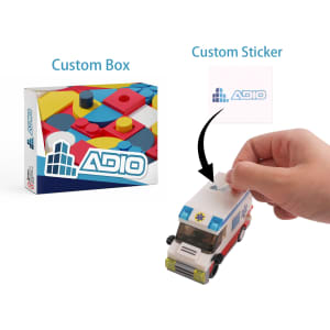 Building blocks set in a colourful box featuring a toy ambulance and a hand applying a custom sticker.