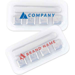 A transparent container holds four stainless steel ice cubes and a metal tongs. The cubes are silver and have a logo.