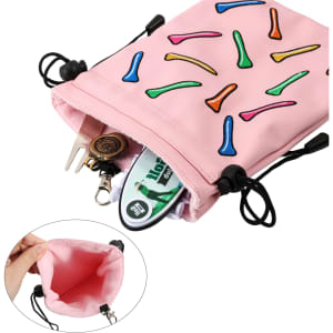 A pink pouch with a playful design, featuring various coloured golf tees, and containing assorted golf accessories.