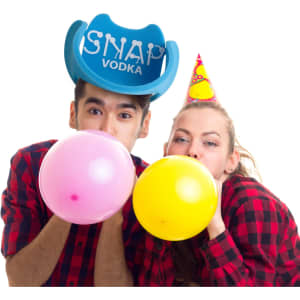 A blue cowboy party hat with branding, worn by two people blowing up pink and yellow balloons, both in checked shirts.