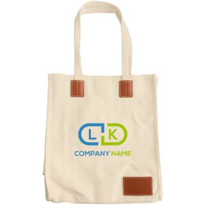 A cream canvas bag with leather accents and a logo, featuring long handles and a magnetic snap closure.