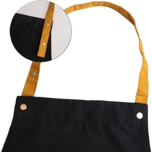 A black poly-cotton canvas apron with a yellow neck strap and snap buttons. Includes a close-up of the strap detail.