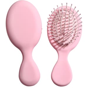 A pink mini paddle brush with a smooth handle and rounded bristles, featuring a simple design.