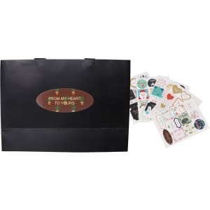 A large black paper bag with flat handles beside various decorative stickers.