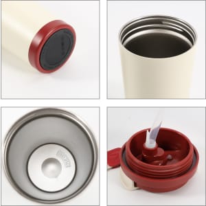 A double wall stainless steel coffee mug in cream with a red lid and base, featuring a logo.