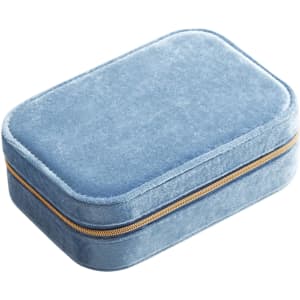 A blue velvet jewellery box with a compartment and a gold zipper, featuring a soft exterior.