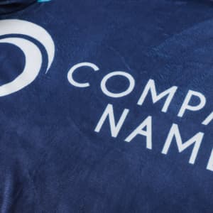 A navy blue blanket made from 100% polyester with a logo and smooth texture.