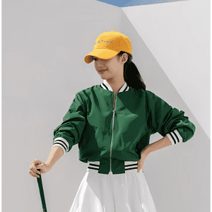 A green bomber jacket with white striped cuffs, paired with a yellow cap that features a logo.