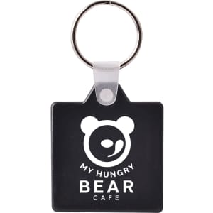 A square hard plastic keyring in black featuring a design with a bear logo and a silver keyring attachment.