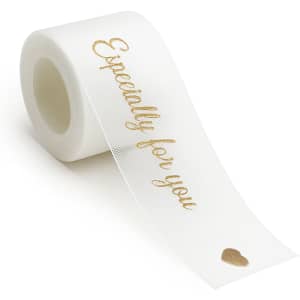 A roll of white organza ribbon with a gold printed message, featuring a small heart design.