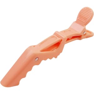 An anti-slip alligator clip in a soft peach colour, featuring a textured grip and a branding logo.