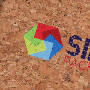A textured cork background featuring a multicoloured geometric logo design.