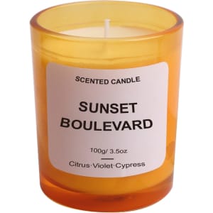 A 3.5oz glass candle in an orange holder, featuring a white label with the scent name and branding.
