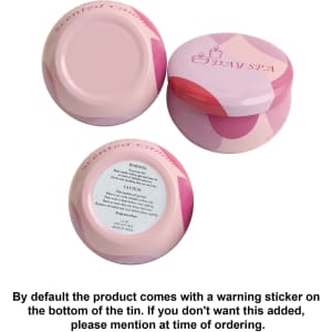A set of pink tin candles with a decorative design, featuring warning stickers on the bottoms.