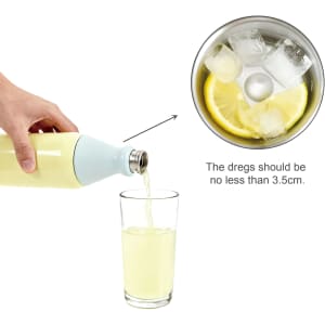 A drink bottle in pale yellow with a light blue cap, pouring liquid into a glass filled with ice and lemon.