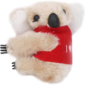 A plush toy koala with beige fur and a red shirt, featuring small black limbs and ears, holding onto a surface.
