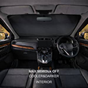 A black reflective car sunshade positioned in a vehicle's dashboard, showcasing a sleek interior design.