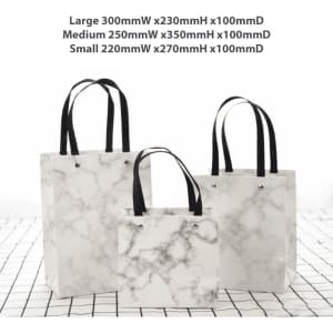 A set of three marble-patterned bags with black handles in varying sizes: large, medium, and small.