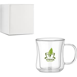 A double wall glass mug with a clear body and handle, packaged in a white box. It features a green logo.