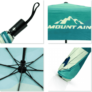 A compact folding umbrella featuring a turquoise and white design with a mountainous pattern and a handle with a logo.