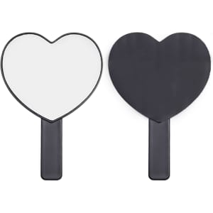 A heart-shaped handheld mirror with a black handle. The mirror is dual-sided, featuring reflective surfaces on both sides.