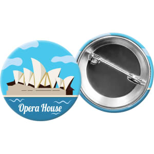 A round button badge featuring a blue design with the Sydney Opera House illustration and a metal pin back.