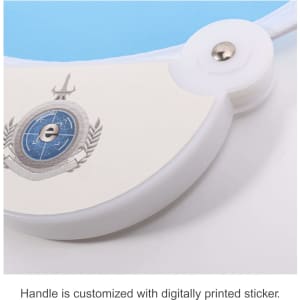 A foldable fan with a blue surface and a white plastic handle featuring a printed design and a metal button.