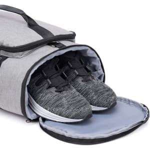 A grey convertible bucket backpack duffel bag with grey and black sports shoes inside, featuring a top opening.