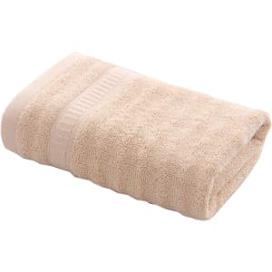 A folded bamboo fibre towel in a light beige shade, featuring a textured surface. The towel is neatly arranged.
