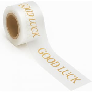 A roll of clear ribbon featuring the phrase "Good Luck" in gold lettering. The ribbon is glossy and stretches out from the roll.