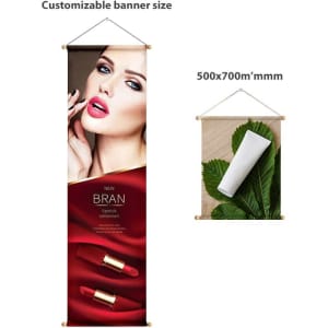 A hanging banner featuring a glamorous model with red lipstick on a red and gold background, and a white rolled-up banner.