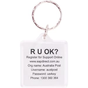 A square acrylic keyring with a clear design and a metal ring, featuring printed text and a logo.
