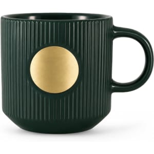 A dark green ceramic mug featuring a ribbed texture and a bronze medal emblem on the front.