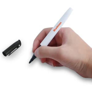 A hand holding a black marker with a white body and a cap beside it, featuring a logo.