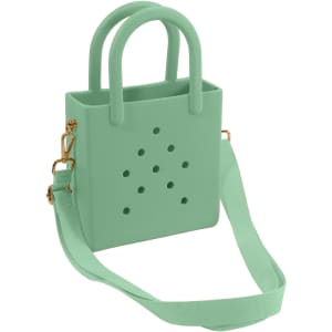 A mint green mini beach bag with perforations, featuring two handles and an adjustable strap. It has a logo.