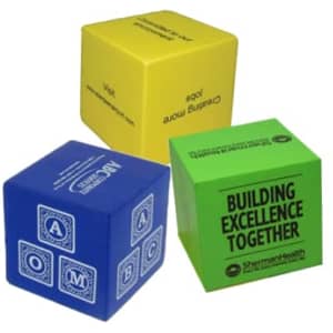 Three cube-shaped stress relievers in yellow, blue, and green, each featuring different designs and a logo.