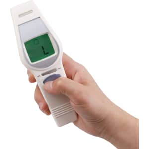 A white touchless digital infrared forehead thermometer held in a hand, featuring a digital display.