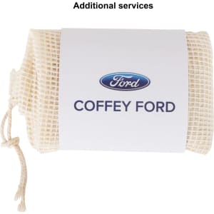 A cream-coloured organic cotton mesh bag tied at the top, featuring a logo on a label.