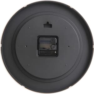 A round wall clock with a wood grain finish and a black back. It features a small rectangular battery compartment.