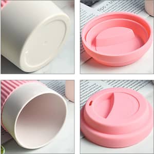A bamboo fibre coffee cup in white with a pink silicone lid, featuring a smooth interior and a circular base.