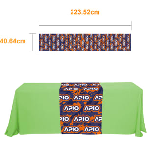 A small table runner in vibrant blue and orange with a branded design, placed on a green tablecloth.