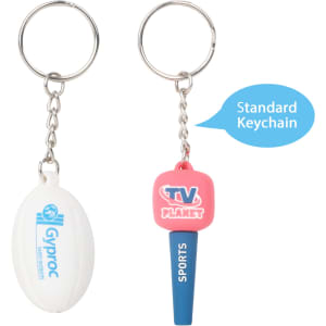 A custom-shaped PVC keyring featuring a rugby ball and a pink keychain with branding. Both are on metal keyrings.