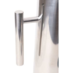 A stainless steel pitcher with a sleek, polished finish and a cylindrical shape, featuring a simple handle.
