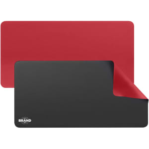 A PU leather desk mat in red and black, featuring a logo on one corner and a smooth surface.