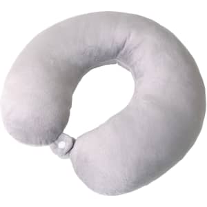 A light grey U-shaped travel pillow with a soft texture and a fastening clip. It has a logo on it.