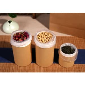 Three small paper cylinder boxes in brown, featuring plastic liners, filled with dried flowers, soybeans, and herbs.