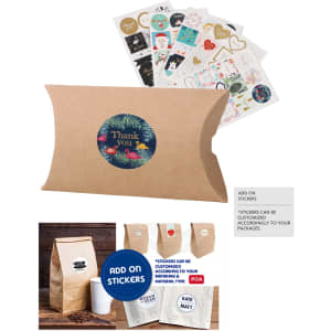 A small brown kraft pillow box featuring a round logo and assorted stickers placed behind it.