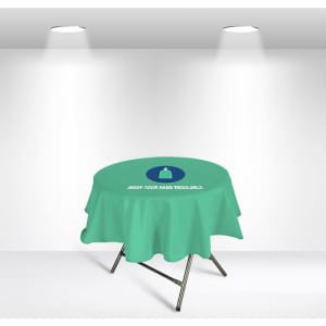 A round table cover in light green with a logo, featuring a message about hand washing.
